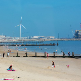 Lowestoft seafront showing the beach and the outer harbour with wind turbine and gas rig.