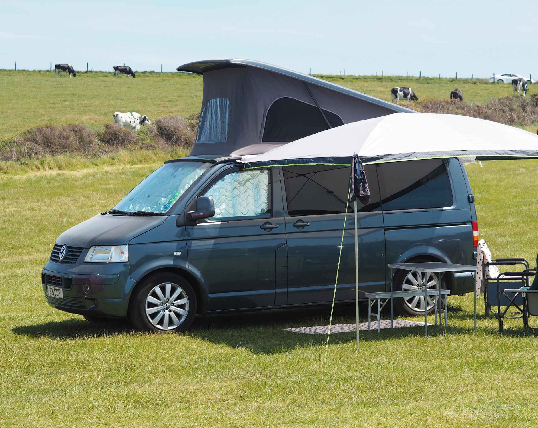 A VW T5 Campervan called Rosie and Reimo Sun Canopy with picnic set up for hire in South Croydon, England
