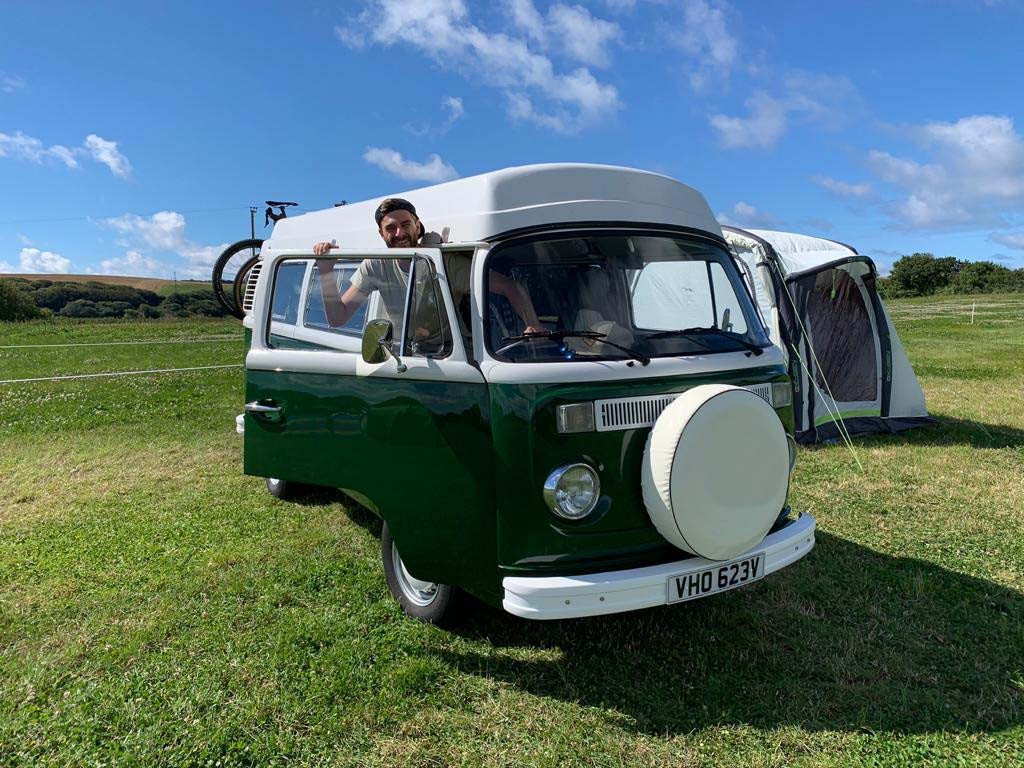 A VW T2 Classic Campervan called Wild-Monty and Wild Monty on campsite for hire in Colyford, Devon